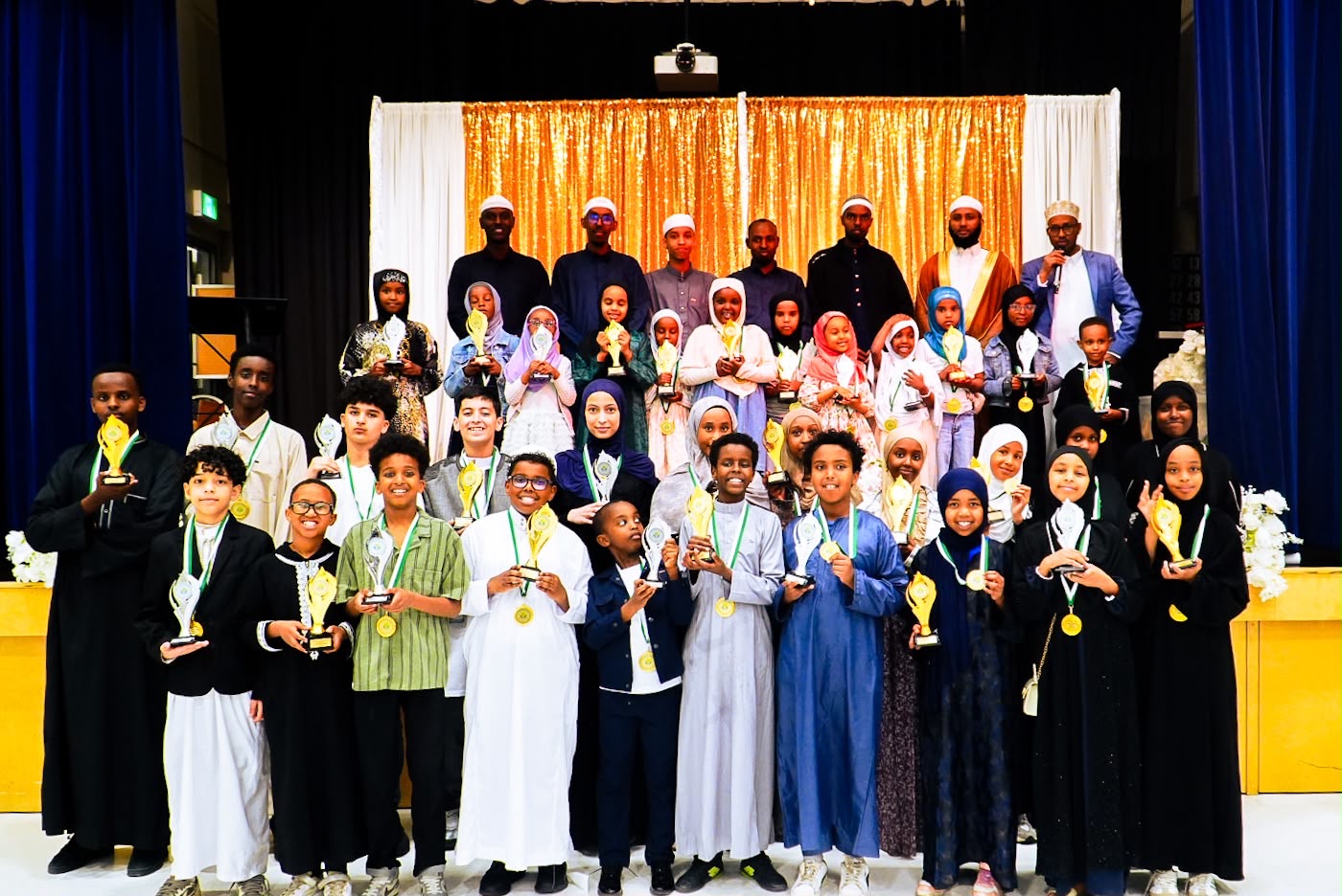 Al-Taqwa Academy students holding awards at the annual ceremony